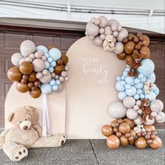 a teddy bear sitting in front of a arch with balloons on it and a sign that says, we can bear wait