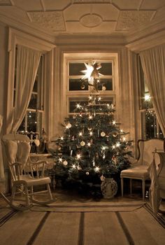 a living room with a christmas tree in the corner and two chairs on the floor