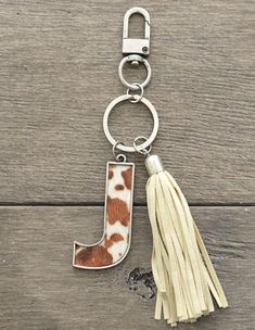 a keychain with a tassel hanging from it's side on a wooden surface