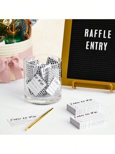 a table topped with cards and a glass filled with money next to a sign that says raffle entry