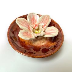 a small ceramic bowl with a flower on it