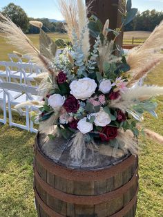 a wooden barrel with flowers and feathers on it