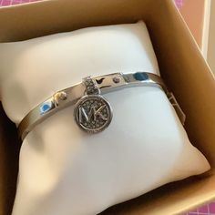 Michael Kors Bangle Bracelet Silver Tone Circle Round Charm Diamonds Paved Logo New With Tag In Box Same Day Shipping Smoke And Pets Free This Michael Kors Bracelet Is A Stunning Piece Of Jewelry That Will Add A Touch Of Elegance To Any Outfit. The Silver Tone Circle Round Charm With Paved Diamonds And Logo Is A Perfect Accessory For Any Occasion. The Bangle Style Bracelet Features A Pav Setting And Comes In A Beautiful Silver Color. The Bracelet Is Made By Michael Kors, A Well-Known Brand In Th Elegant Silver Bracelet With Logo Charm, Elegant Adjustable Jewelry With Logo Charm, Adjustable Silver Bracelet With Logo Charm, Luxury Adjustable Bangle Charm Bracelet, Adjustable Logo Charm Bracelet, Silver Charm Bangle Bracelet, Silver Bracelets With Logo Charm For Gift, Silver Bracelets With Logo Charm As Gift, Metal Bracelet With Logo Charm As A Gift