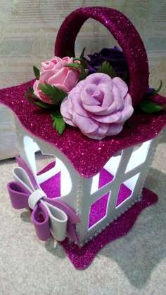 a pink and white box with flowers on it sitting on a table next to a wall