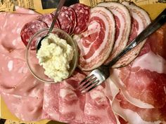 a plate with meats, mashed potatoes and a fork next to it on a table