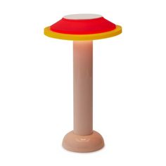 a red, yellow and orange table lamp on a white background with no one around it