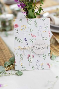 a card with flowers on it sitting on top of a table