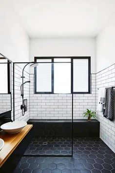 black and white bathroom with hexagonal tile flooring, wooden countertop, two sinks