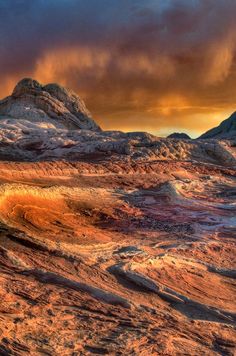 the mountains are covered in brown and orange colors as the sun goes down over them