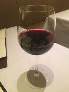 a glass of wine sitting on top of a table