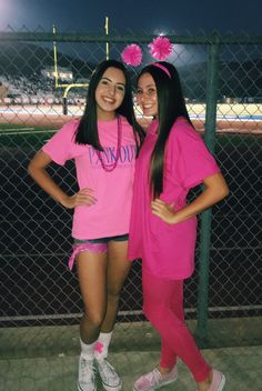 two girls in pink shirts posing for the camera