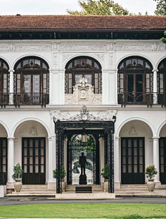 the front entrance to a large white building with lots of windows and balconies