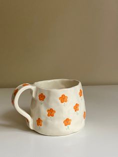 a white cup with orange flowers on it