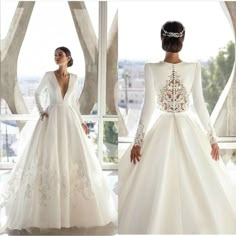 a woman in a white wedding dress standing next to a window