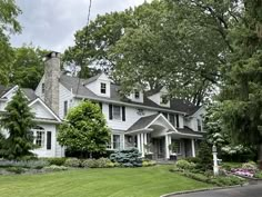 a large white house sitting on top of a lush green field