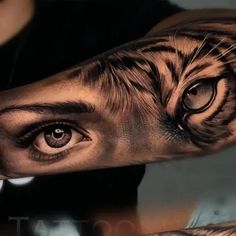 a man's arm with a tiger tattoo on it and an eye in the middle