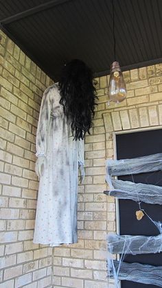 a woman's dress hanging on the side of a brick building