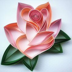 a paper flower made to look like an origami rose with leaves on it