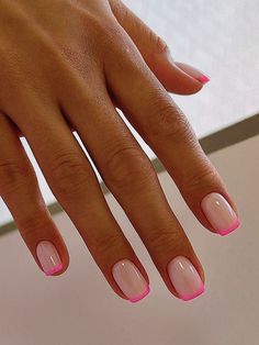 a woman's hand with pink and white manies on her nails is shown