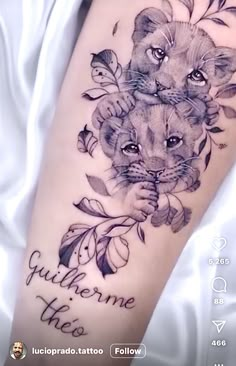 a tattoo on the leg of a woman that has two lions and leaves around it