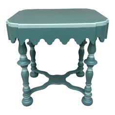 a small blue table with scalloped legs