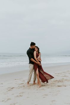 an engaged couple embracing on the beach