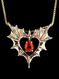 "Two bat or dragon wings meet to form one heart. Open your heart to Love. The Phantom Heart Pendant is cast in 14k gold, is 1 1/16\" wide by 1 1/8\" tall and carefully detailed both front and back. A brilliant pear-shaped 5mm x 7mm gemstone is set in the open center. Treat yourself or gift that special someone, this wickedly wonderful token of love. Please select your desired gemstone in the dropdown options menu. You may choose between a Blue Topaz, Citrine, Amethyst, Peridot, Mozambique Garnet Unique Ear Cuffs, Dragon Ear Cuffs, Winged Heart, Silver Gold Jewelry, Swirl Earrings, Dragon Jewelry, Dragon Wings, Wing Necklace, Gold Heart Necklace