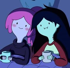 two women sitting on a bed holding coffee mugs