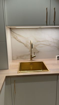 a kitchen with marble counter tops and gold sink faucet in the center,