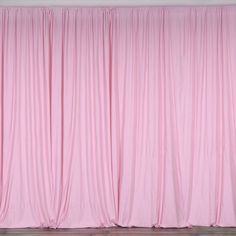 a pink curtain in front of a white wall