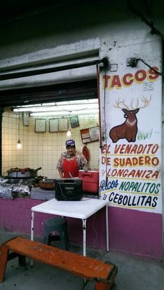 a man sitting at a table in front of a store