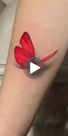 a woman's arm with a red butterfly tattoo on it