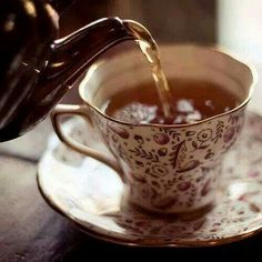 tea being poured into a cup on a saucer