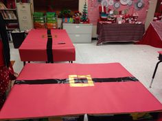 the tables are covered with red cloths and black ribbon for christmas party guests to sit at