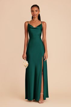 a woman in a long green dress with a slit down the side and her hand on her hip