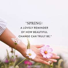 a woman's hand holding flowers with the words spring, a lovely reminder of how beautiful change can truly be