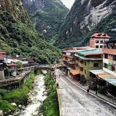 a river running through a small town surrounded by mountains