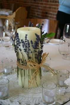 there is a candle with lavender flowers in it on the table