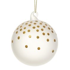 a white ornament with gold dots on it