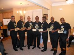 a group of men standing next to each other holding up signs with numbers on them