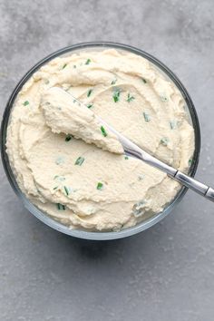 a glass bowl filled with cream and green sprinkles next to a spoon