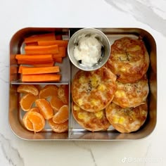 a metal tray with carrots, biscuits and other food items