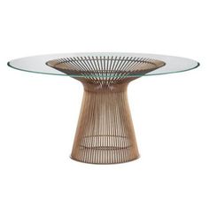 the table is made out of wicker with glass top and round base, it has an oval shape