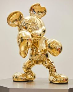 a gold mickey mouse statue on top of a table