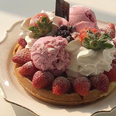 a waffle topped with whipped cream and strawberries