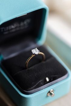 an engagement ring in a blue box on a table