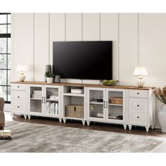 a living room with a large flat screen tv on top of a wooden entertainment center