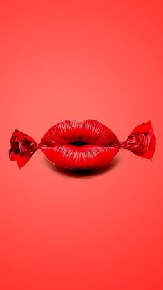 a red lip with two candy sticks sticking out of it's mouth on a red background