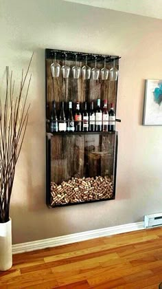 a wall mounted wine rack filled with lots of bottles next to a vase full of branches