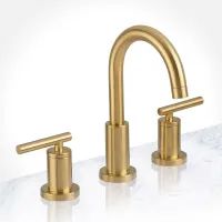 two gold faucets on a marble countertop